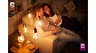 Couple looking t each other in a dark room with cozy lights