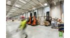 Stockroom with a forkliftruck and a worker in a warehouse
