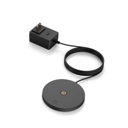 Black Belle portable lamp charging base with matte finish, circular shape, visible power adapter, and central charging contact.