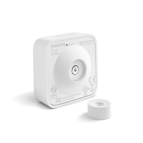 White square motion sensor with rounded edges, matte finish, central button, and cylindrical accessory placed in front. Text: Motion sensor.