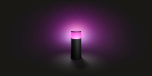 A cylindrical black lamp emits a soft purple glow, creating gentle ambient lighting against a dark background.