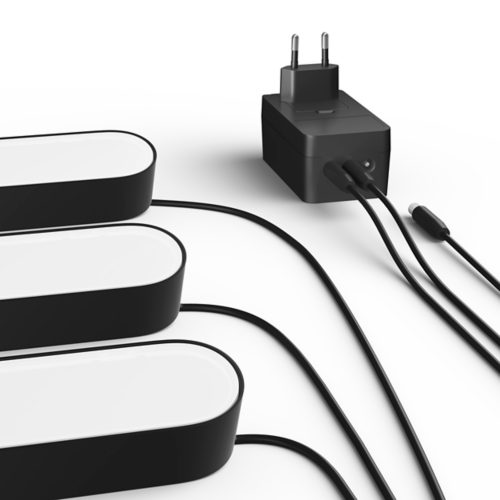A collection of black smart light bars connected to a black power adapter with multiple cables on a white surface.
