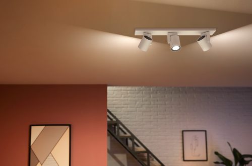 Ceiling-mounted white plate with a collection of adjustable spotlights directing light onto the ceiling and walls of a modern room.