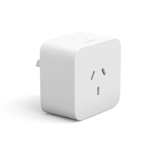 White smart plug with a square shape, matte finish, visible prong slots, and a circular button on the top surface.