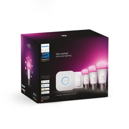 Box displaying smart lighting starter kit with three color light bulbs, a bridge device, and a dimmer switch against a pink background.