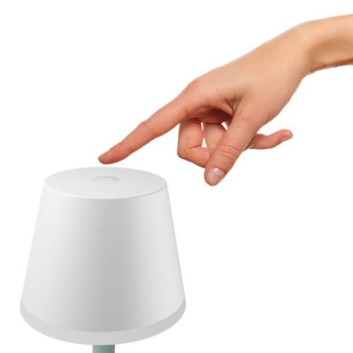 Finger pressing the button on top of a white portable lamp, likely to turn it on or off.