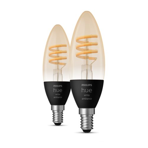 Collection of filament candle-shaped smart bulbs with black matte base, silver screw, amber glass, and visible spiral filament. Text: hue white ambiance.