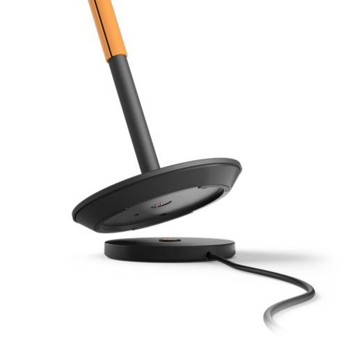 Close-up of the black lamp base with visible charging pins, matte finish, and a round charging pad connected by a cable.