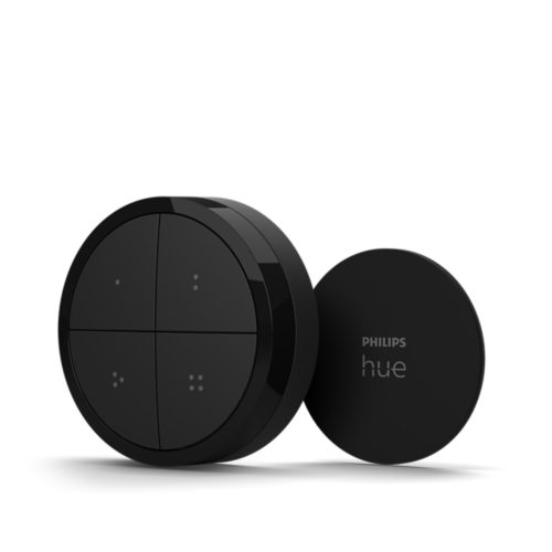 Black circular smart tap dial switch with matte finish, four tactile buttons, and compact round mounting plate showing text PHILIPS hue.