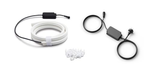 Coiled outdoor lightstrip with black power adapter, extension cable, and a collection of white mounting clips on a white background.