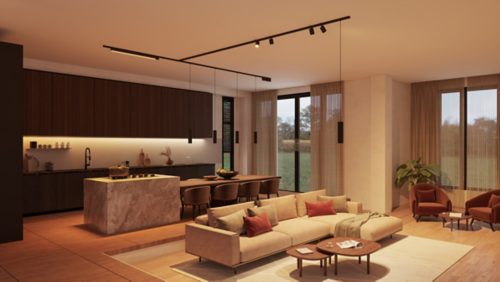 Black T-connector track lighting system mounted on ceiling, directing light onto kitchen island and living room seating area below.